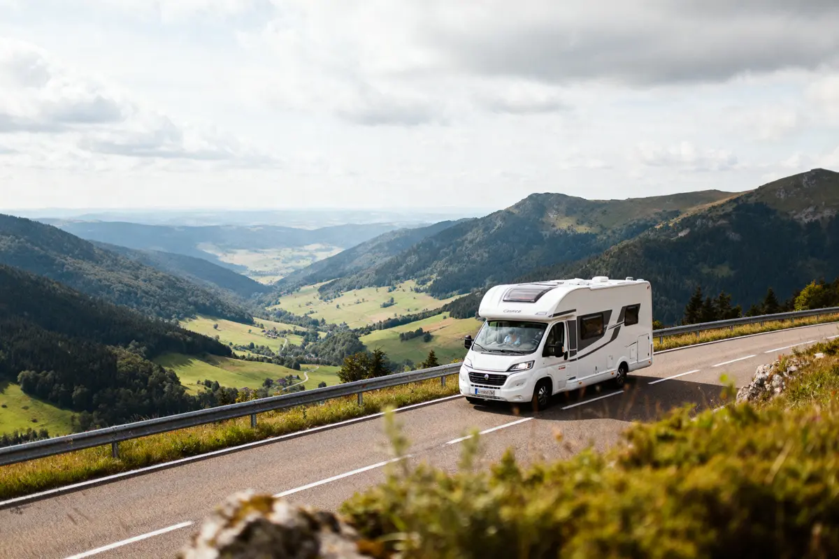 Camping-car sur route panoramique à travers les Vosges en camping car avec vallées verdoyantes