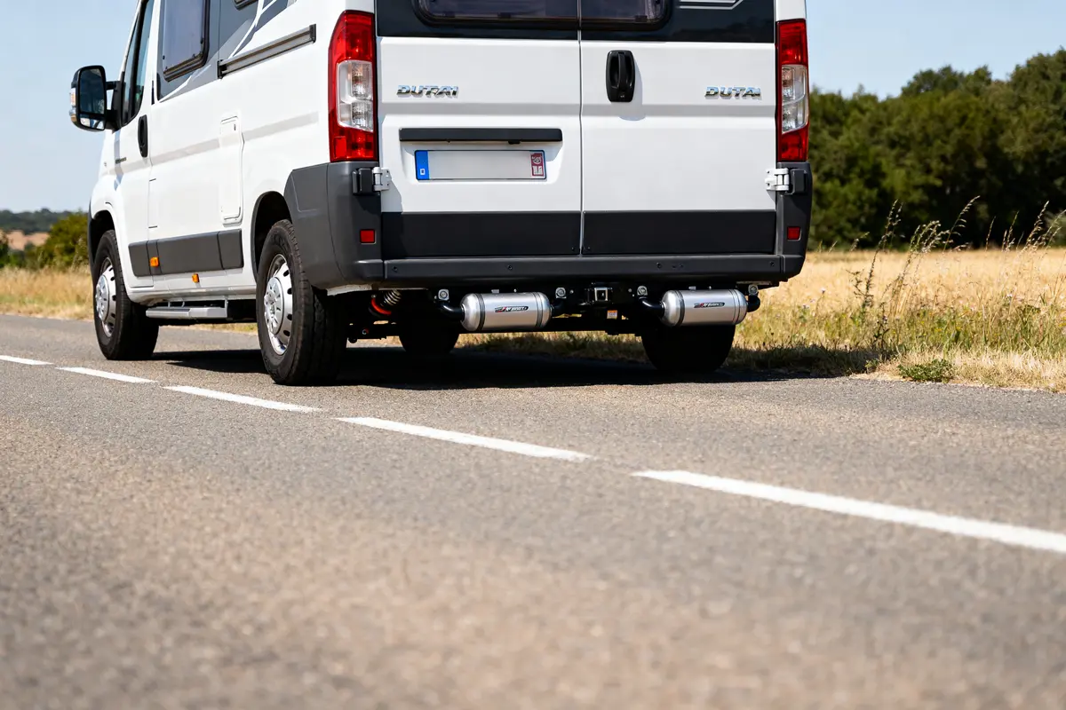 Camping-car Fiat Ducato sur route avec kit suspension pneumatique visible à l'arrière